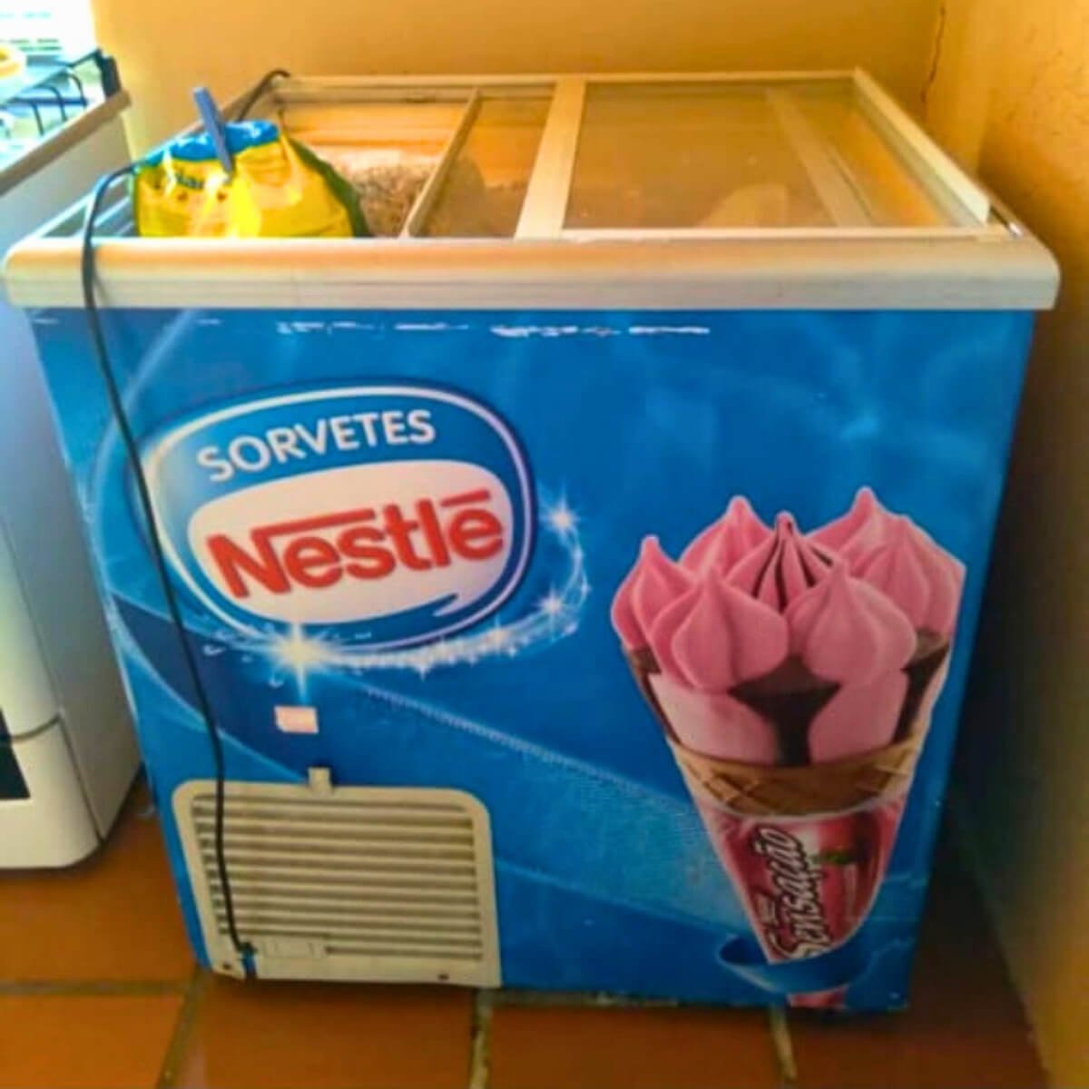 Freezer horizontal comercial de sorvetes com tampa de vidro em funcionamento após manutenção técnica em Curitiba.