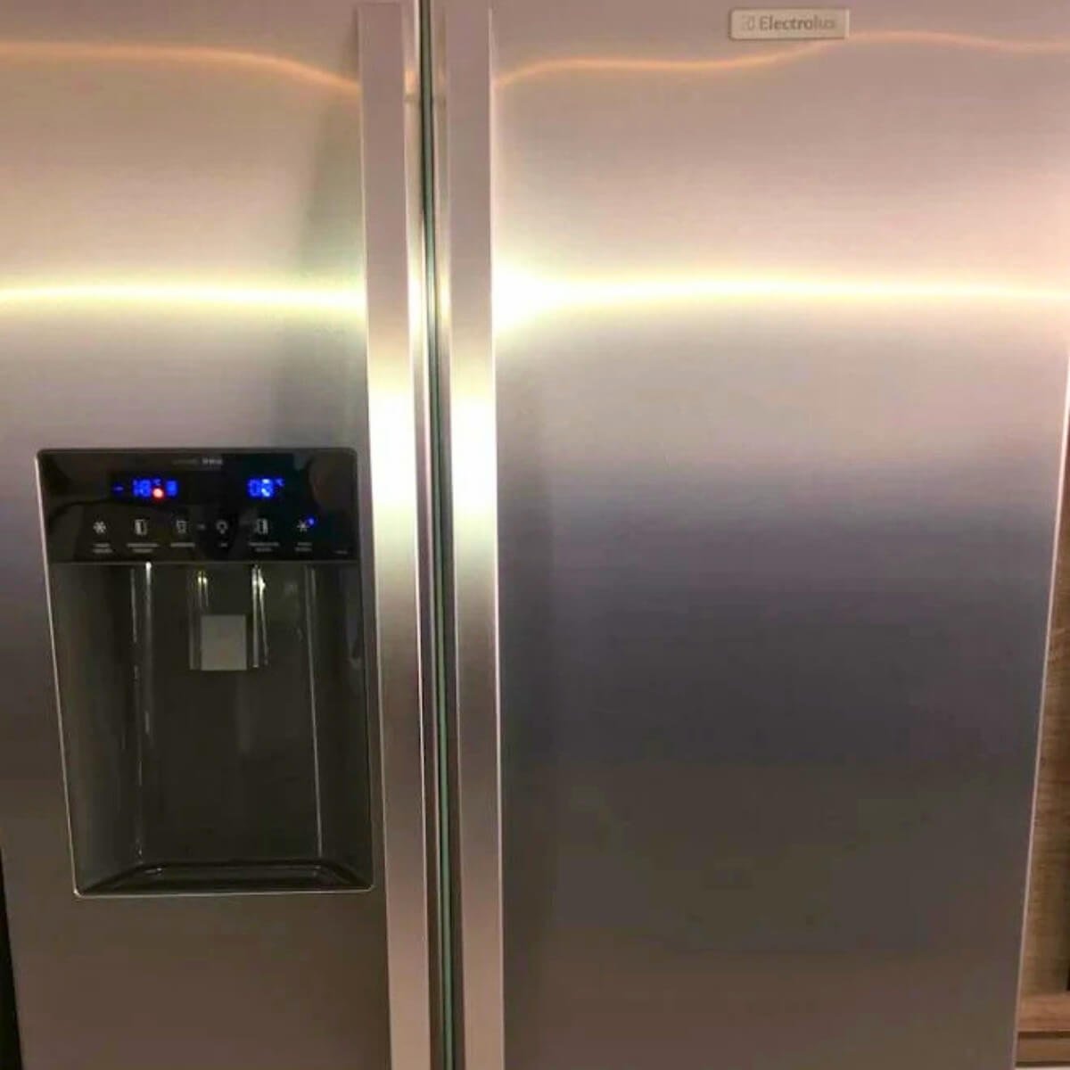 Detalhe do painel digital e dispenser de água de refrigerador Side by Side em pleno funcionamento.