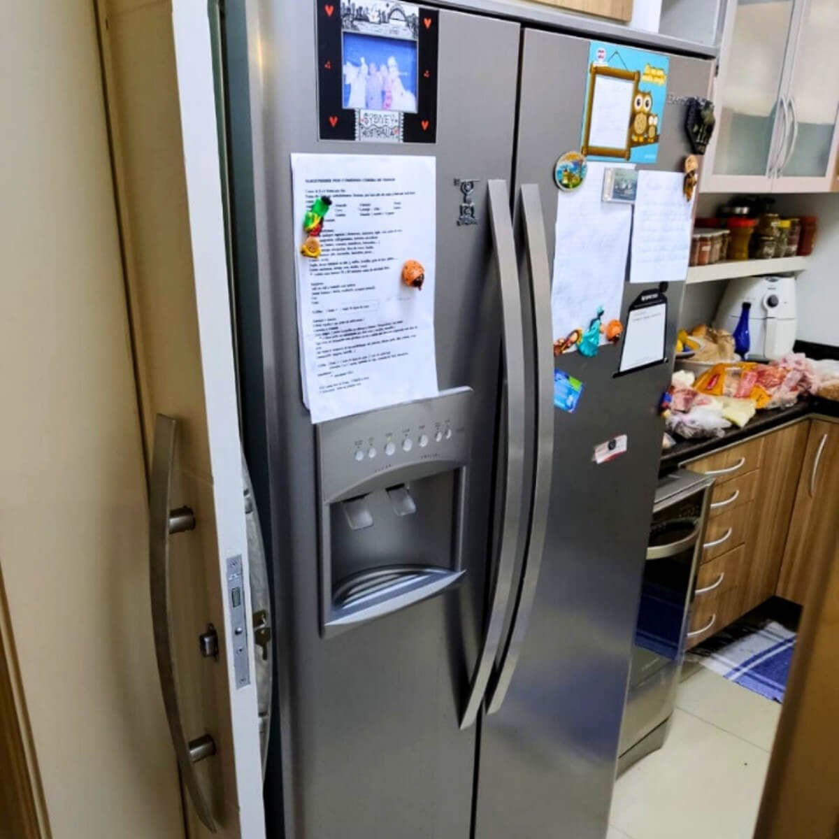Geladeira Side by Side com dispenser de água e gelo em pleno funcionamento na cozinha do cliente.