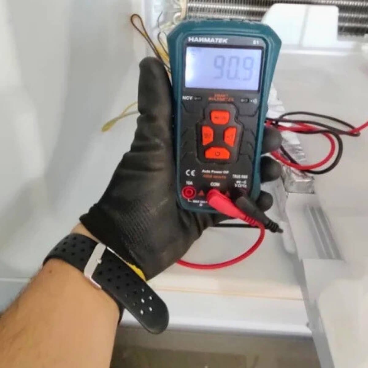Técnico utilizando multímetro digital para diagnóstico de sensores em geladeira Frost Free durante atendimento em Curitiba.