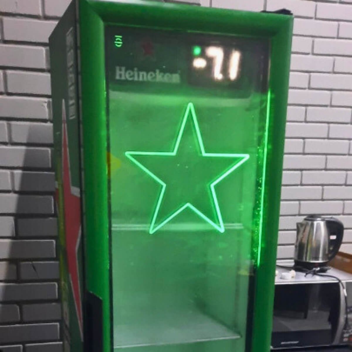 Cervejeira expositora verde da Heineken com display digital marcando temperatura negativa após conserto do controlador.